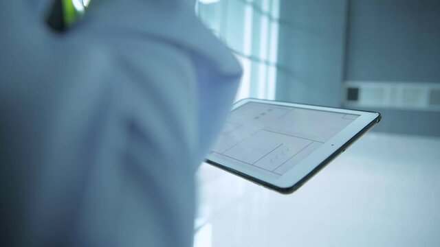 Engineer concept. A business man looking at the structure diagram in a tablet computer. 4k Resolution.