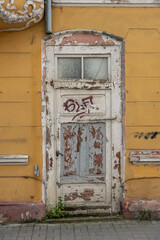 Old shabby front door to the building.