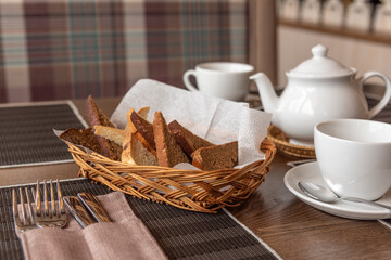 Basket of bread and tea set on the table in the cafe.