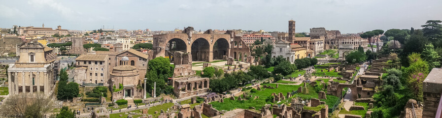 Ultra wide view of the ancient Roman Forum and the Colosseum in background in Rome