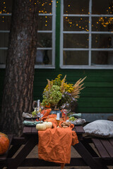 Fall themed holiday table setting arrangement for a seasonal party in the yard