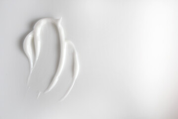 A smear of white cream on a white background.
