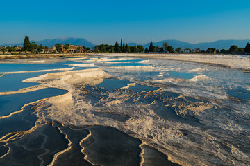 Natural travertine pools and terraces at sunset in Pamukkale, Turkey