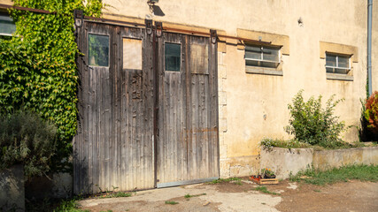Fototapeta premium Large garage door in worn wood, and old structure