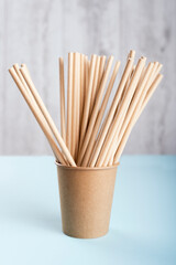 Biodegradable cup with drinking straws on light grey background. 