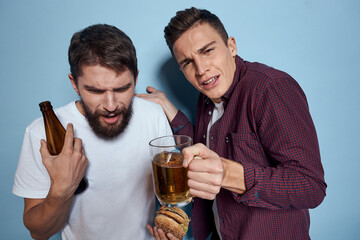 Two cheerful drunk friends drinking beer lifestyle emotions on a blue background
