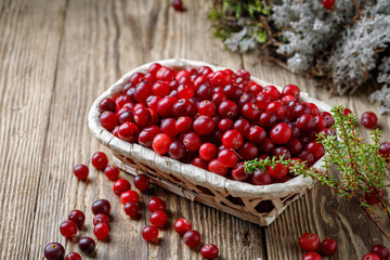 Basket with cranberries on a wooden table