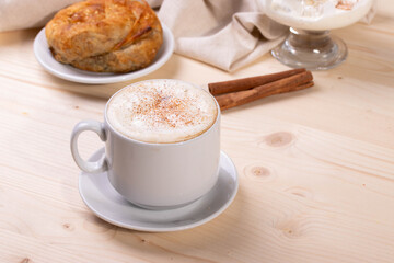 a white ceramic cup of cappucino as a coffee break concept