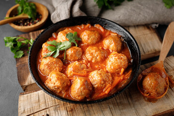 Meatballs in a pan in sweet and sour tomato sauce