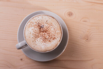 a white ceramic cup of cappucino as a coffee break concept