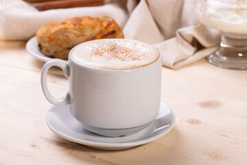 a white ceramic cup of cappucino as a coffee break concept