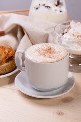 a white ceramic cup of cappucino as a coffee break concept