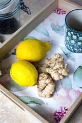 Two lemons and ginger on pastel plate, green cup in background