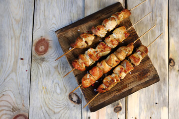 Chicken skewers on wooden sticks. Appetizing homemade mini barbecue. Selective focus. Macro.