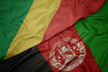 waving colorful flag of afghanistan and national flag of republic of the congo. macro