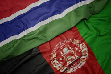 waving colorful flag of afghanistan and national flag of gambia. macro