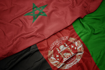 waving colorful flag of afghanistan and national flag of morocco. macro