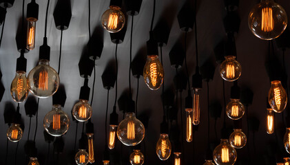 Retro Edison lamp on a black background of the ceiling. Concept idea