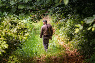 Hunter following a forest trail in search for deer