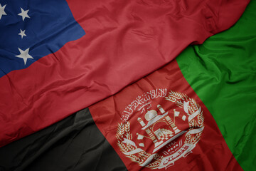 waving colorful flag of afghanistan and national flag of Samoa . macro