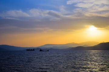 cargo ship travels at sunset