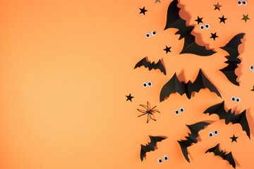 Halloween frame template with black paper bats and plastic spooky eyes on a yellow background.