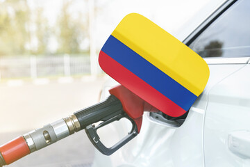 Flag of Colombia on the car's fuel filler flap with gas pump nozzle in the tank.