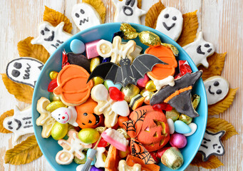 happy halloween card background, Jack o Lantern candy bowl with sweets and halloween cookies Trick or Treat  surrounded by festive decor spiders, bats, skull