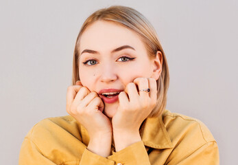 Surprised young woman smiling in studio isolated on gray background