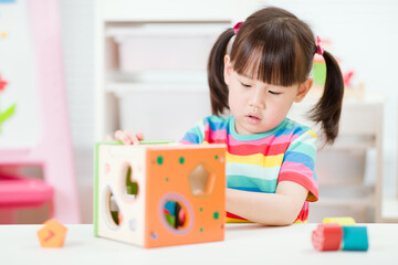 young  girl playing number shape blocks for homeschooling