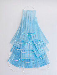 Christmas tree made of disposable medical masks isolated on white.