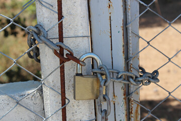 Door locked with old padlock and rusty chain. Entrance is forbidden.