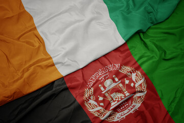 waving colorful flag of afghanistan and national flag of cote divoire. macro