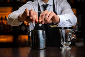 Fototapeta na wymiar A young smiling bartender in a black apron prepares mulled wine 