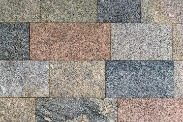 Wall lined with stone slabs. Polished granite of different types and colors: black, gray, red, pink...