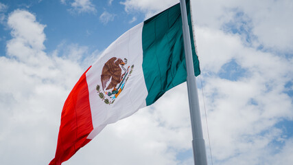 Mexican Flag Waving in the Wind Under a Blue Sky
