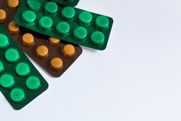  pills into green and brown blister on white background top view pharmacy medical industry concept