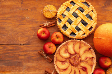 Thanksgiving berry and apple various pies on wooden surface, top view