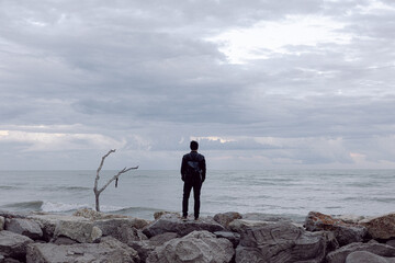 Ragazzo sugli scogli guarda il mare 