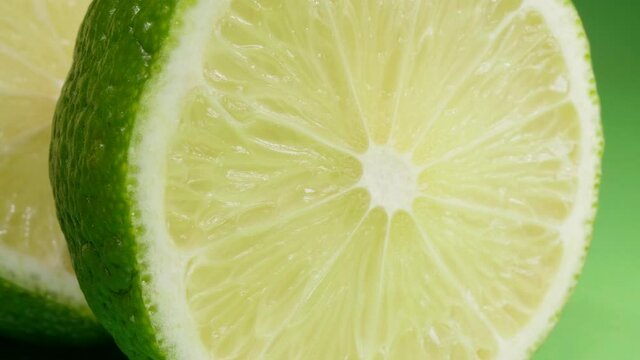 Lime halves on a green background. Citrus fruit. Macro.