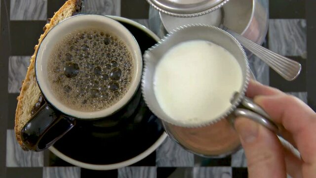 Putting milk and sugar into the coffe