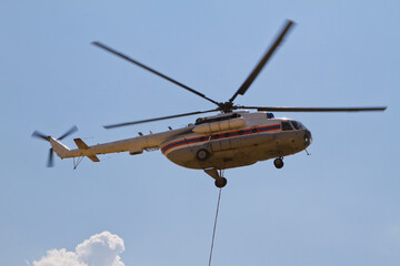 Firefighting helicopter with fire bucket flies