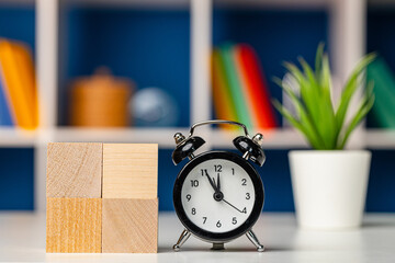 Four wooden cubes with copy space and alarm clock