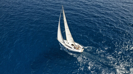 Aerial drone photo of sailboat cruising in Mediterranean deep blue open ocean sea