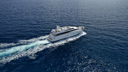 Naklejka premium Aerial drone photo of small luxury yacht cruising the Aegean deep blue open ocean sea