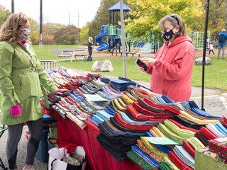 woman looking at colorful fabrics on a table at an outdoor markets