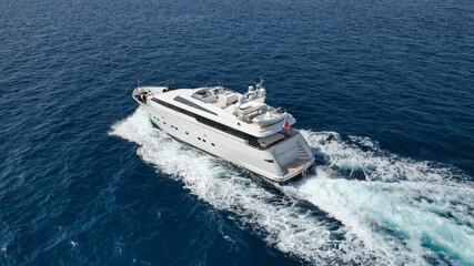 Aerial drone photo of small luxury yacht cruising the Aegean deep blue open ocean sea
