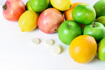 Green apples, mandarins, oranges, limons, garnets and multivitamins isolated on the white background. Healthy food boost immunity system concept.