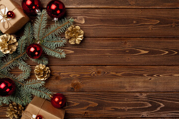 Spruce branches and red Christmas baubles top view