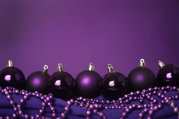 Purple Christmas tree decorations with purple beads on a purple background. New Year decoration.